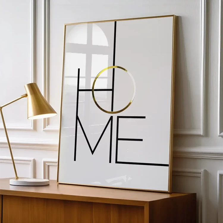 Typograficzny plakat z napisem HOME, czarne minimalistyczne czarne litery i złoty akcent w postaci litery O na białym tle